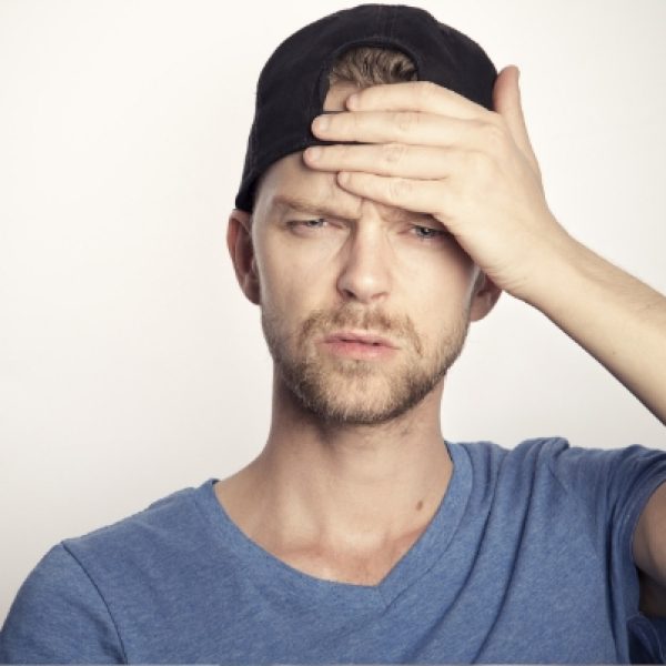 man holding hand to his head to feel temperature