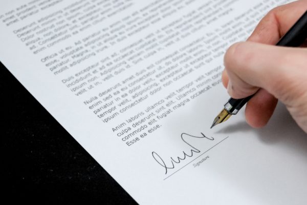 person giving signature on a document