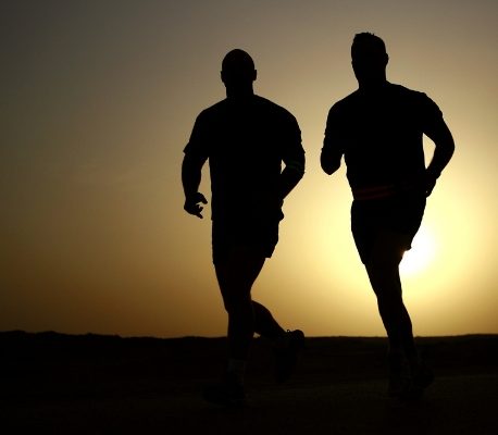 two people running with sun rising behind them