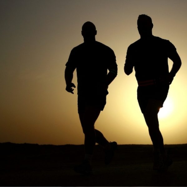 two people running with sun rising behind them